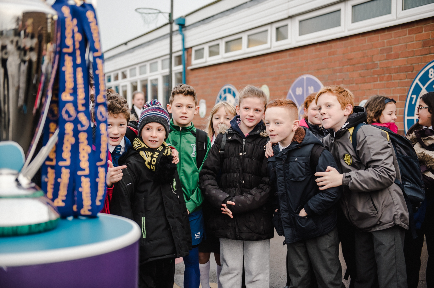 Children looking at the Premier League trophy